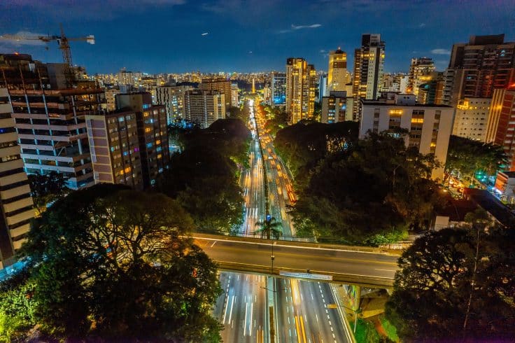 Cidade com luzes e veículos em movimento funcionando através da matriz energética.